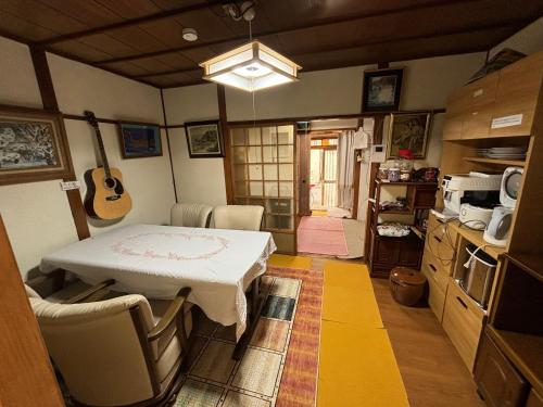 una cucina con tavolo e chitarra appesa al muro di AnNam Stay HOTARUGAIKE - - whole two story house rental a Toyonaka