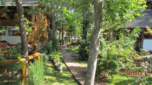 un jardín con árboles y flores y una valla en Cabañas Tehuel en Las Gaviotas