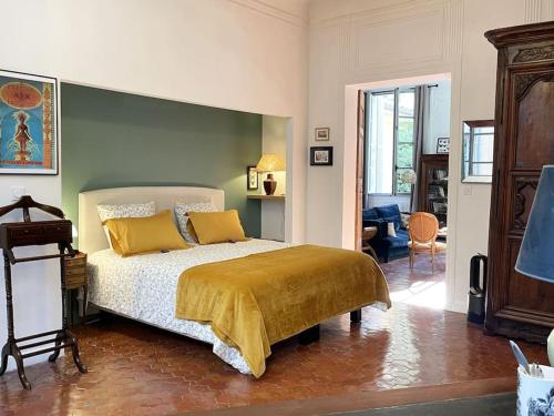 une chambre avec un lit avec des oreillers jaunes dans l'établissement Appart d exception 2 chambres quartier Mazarin, à Aix-en-Provence