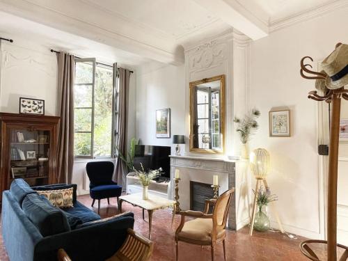 un salon avec un canapé bleu et une cheminée dans l'établissement Appart d exception 2 chambres quartier Mazarin, à Aix-en-Provence