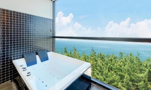 a bathroom with a sink and a view of the ocean at Gangneung Music Time Spa Pension in Gangneung