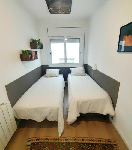 two beds in a small room with a window at Vacation house in the mountains in Esparraguera