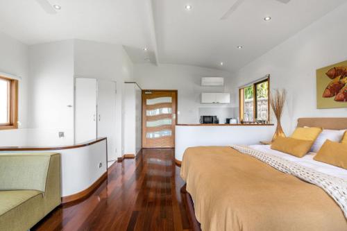 a bedroom with a large bed and a couch at Cape Byron Villa 7 Romantic Serenity with Views in Byron Bay