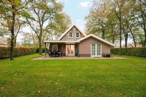 a small pink house with a grass yard at Buitengoed het Lageveld 75 in Hoge-Hexel
