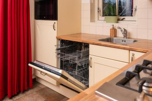 a dishwasher in a kitchen next to a sink at Buitengoed het Lageveld 75 in Hoge-Hexel