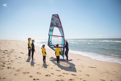 a group of people on the beach with a wind sail at TUI BLUE Sylt in Rantum