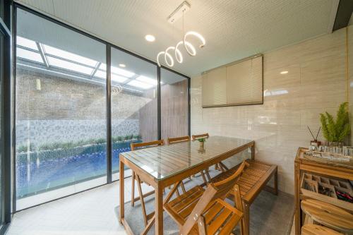 a dining room with a wooden table and chairs at Huerim Pool Villa Private Pension in Ch'ŏn'gun-ni
