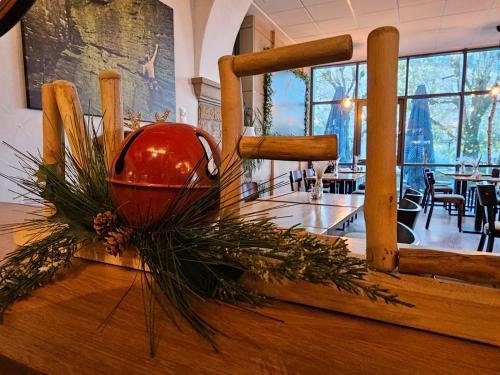 a red vase on a table with a christmas decoration at Trail-Inn Natur & Sporthotel in Berdorf