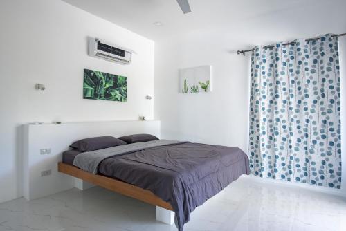 a bedroom with a bed and a blue shower curtain at Corsita Resort Koh Mak in Ko Mak