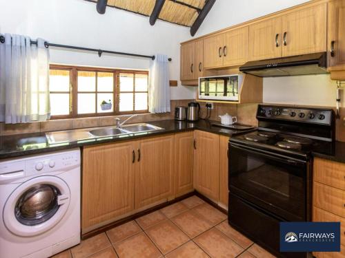 a kitchen with a washer and a dishwasher at Fairways Drakensberg Resort in Drakensberg Garden