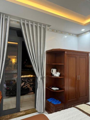 a room with a bed and a cabinet with curtains at Kiều Tiên Hotel in Long Thành