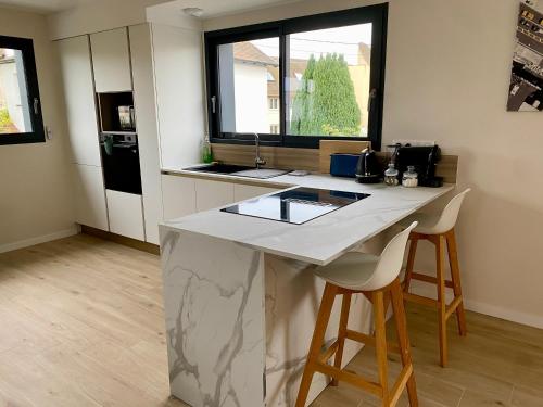 a kitchen with a counter and two stools in it at Chez Sam in Oberhausbergen