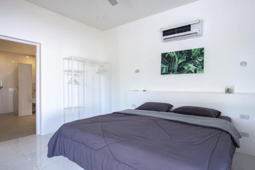 a white bedroom with a bed and a window at Corsita Resort Koh Mak in Ko Mak
