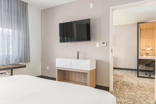 a hotel room with a bed and a tv on the wall at SpringHill Suites by Marriott Freeport Brunswick in Freeport