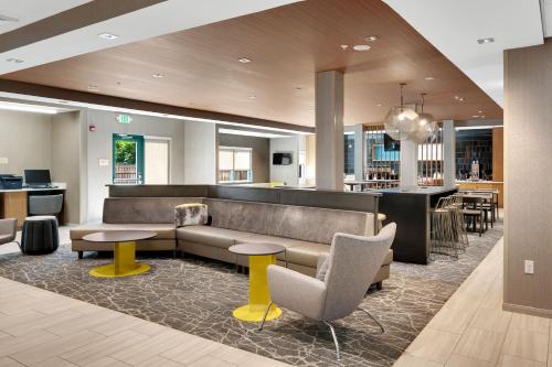 a lobby with a couch and tables and a bar at SpringHill Suites by Marriott Freeport Brunswick in Freeport