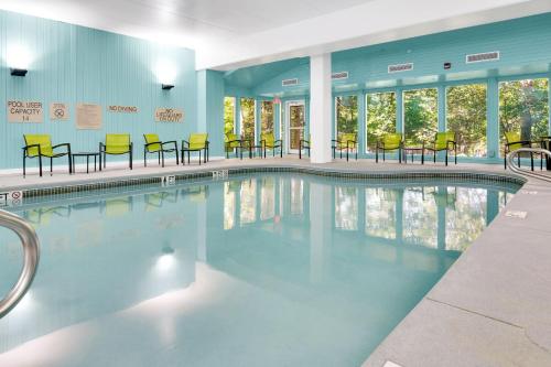 a swimming pool with yellow chairs and tables at SpringHill Suites by Marriott Freeport Brunswick in Freeport