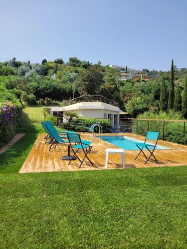 - une terrasse avec des chaises et une piscine dans la cour dans l'établissement Villa Neuve avec magnifique vue Mer, à Mandelieu-la-Napoule
