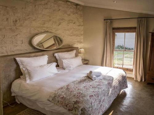 a bedroom with a large bed with a teddy bear on it at Dalmore Guest Farm in Bergville