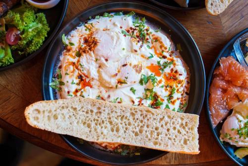 einen Tisch mit einem Teller Essen und einer Schüssel Suppe in der Unterkunft Motlawa Apartments Gdansk Old Town in Danzig