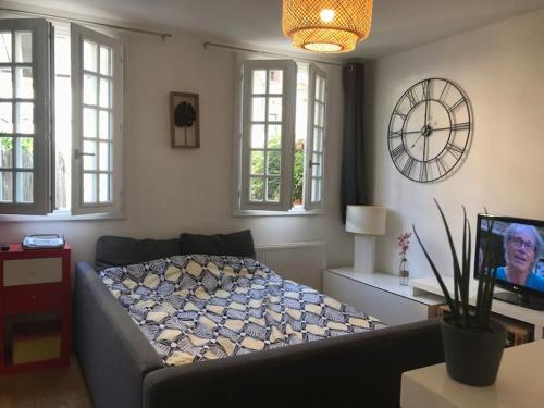 une chambre avec un lit et une horloge au mur dans l'établissement Appart Terrasse Centre ville Parking facile, à Auxerre