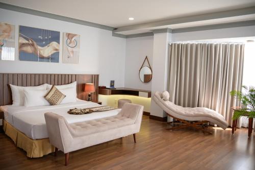 a bedroom with a large white bed and a chair at Saigon - Ninh Chu Hotel & Resort in Phan Rang