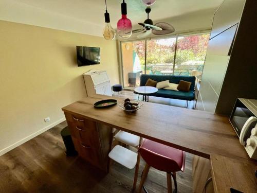 Il comprend une cuisine avec une table en bois et un salon. dans l'établissement Le green bay piscine avec parking Pick up aéroport, à Roquebrune-Cap-Martin