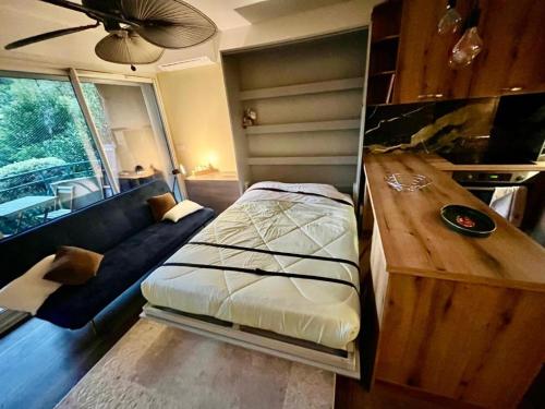 un salon avec un lit et un canapé dans l'établissement Le green bay piscine avec parking Pick up aéroport, à Roquebrune-Cap-Martin