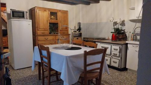 Il comprend une cuisine équipée d'une table blanche et d'un réfrigérateur blanc. dans l'établissement Vers La Grange, à Arbusigny