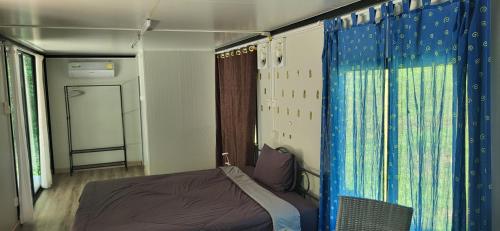 a small bedroom with a bed and a window at Corsita Resort Koh Mak in Ko Mak