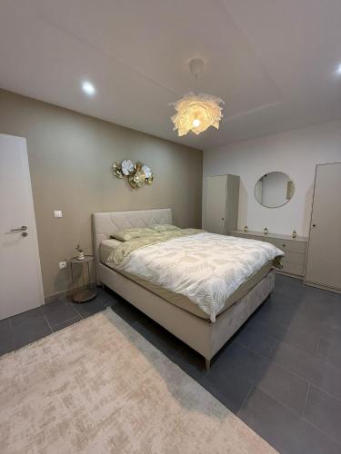 une chambre avec un grand lit et un lustre dans l'établissement Cosy & Dark Appartements, à Mundolsheim