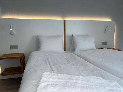 a bedroom with two beds with white sheets at Hotel Drei Könige in Chur