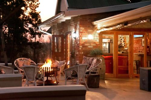a patio with chairs and a fire pit at night at Dalmore Guest Farm in Bergville