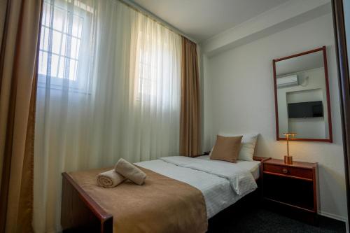 a bedroom with a bed with a mirror and a window at Attache Vila in Kruševac