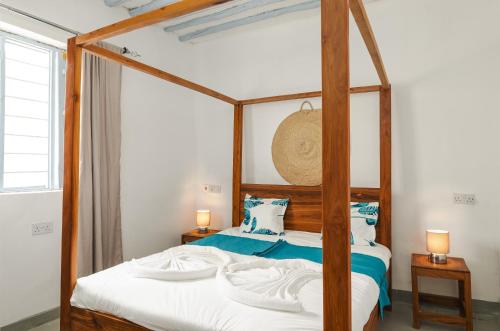 a bedroom with a canopy bed with white sheets at Zanzibari holiday home by Liv Zanzibar in Paje