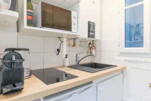 une cuisine avec un évier et un micro-ondes dans l'établissement Beautiful Apartment- 1BR-4P - Sacré-Cœur, à Paris