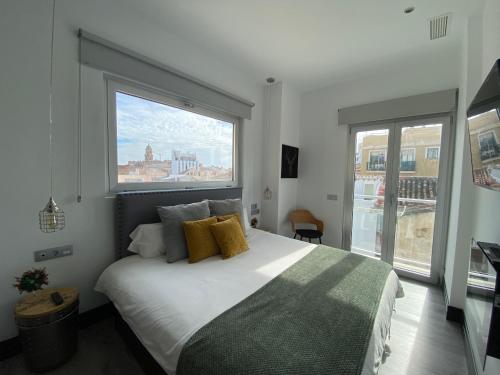 a bedroom with a large bed with a large window at Stay Unique Apartments Rosaleda cerca Museo Picasso in Málaga