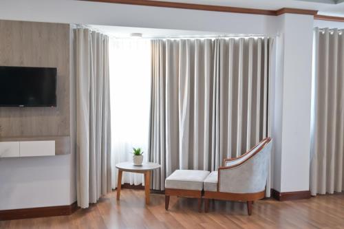 a living room with a chair and a television at Saigon - Ninh Chu Hotel & Resort in Phan Rang