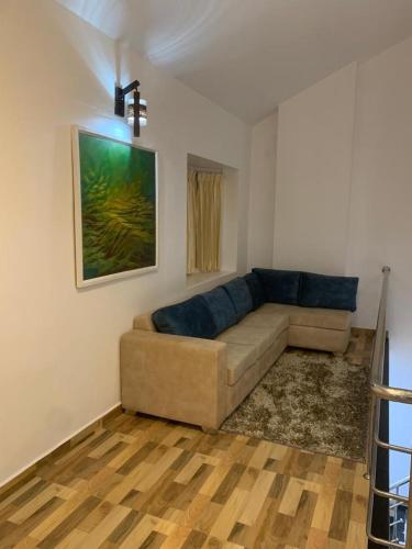 a living room with a couch and a painting on the wall at Memmsta ASK Villa - Kodaikanal in Kodaikānāl