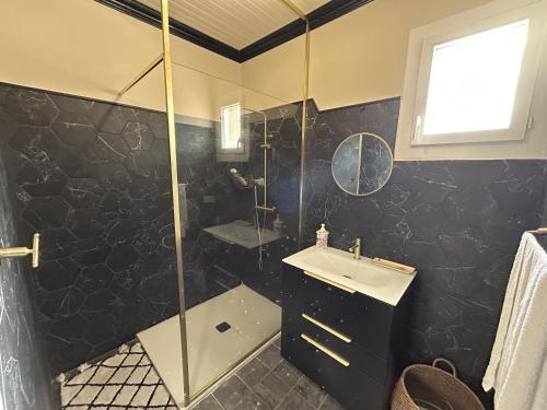 une salle de bain avec douche et lavabo dans l'établissement Appartement de charme vue mer, à Kamiesch