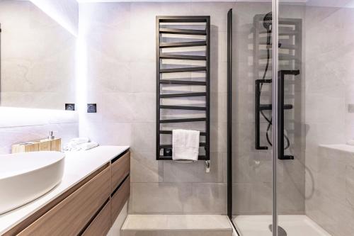 une salle de bain blanche avec une douche et un lavabo dans l'établissement Brand New 3 bedrooms Facing Madeleine/St Honoré, à Paris