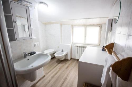 a white bathroom with a sink and a toilet at Casa Liscidini in Aprica