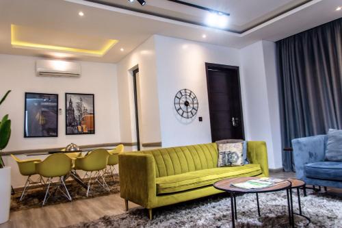 a living room with a green couch and a table at George Residence Lekki in Lekki