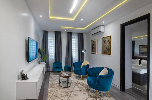 a hotel room with blue chairs and a bed at George Residence Lekki in Lekki