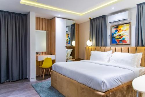 a bedroom with a large bed and a yellow chair at George Residence Lekki in Lekki