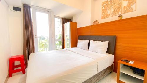 ein Schlafzimmer mit einem großen Bett mit Fenster in der Unterkunft Comfortable Studio Room at Tokyo Riverside Apartment By Travelio in Rawalembang