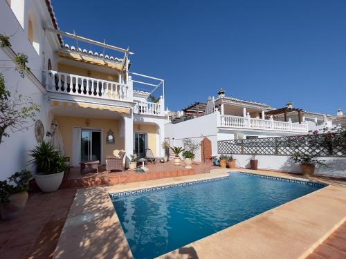 a villa with a swimming pool in front of a house at Rd02 La Casa Hermosa in Torrox