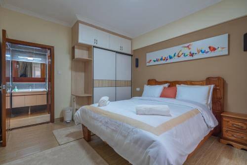 a bedroom with a large white bed and a window at Exquisite Condo with Free parking Gym and Pool in Nairobi