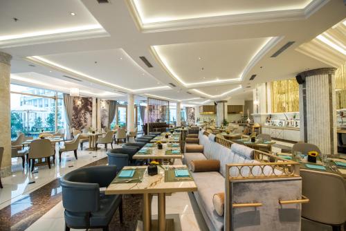 Vinpearl Resort & Spa Ha Long في ها لونغ: مطعم به طاولات وكراسي في غرفة