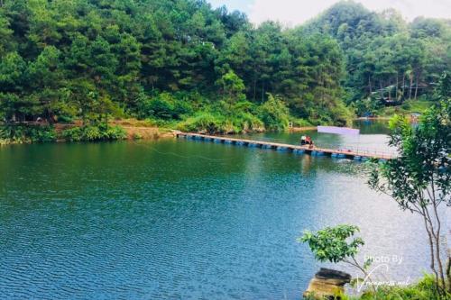 un ponte sopra un lago con delle persone sopra di NaNa Farm a Bak Kan