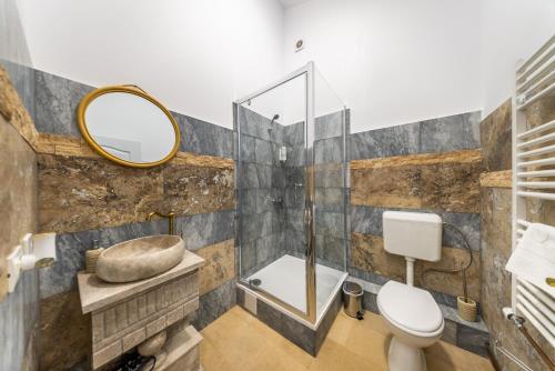 een badkamer met een toilet en een spiegel bij La Casa Blanca in Vladimirescu